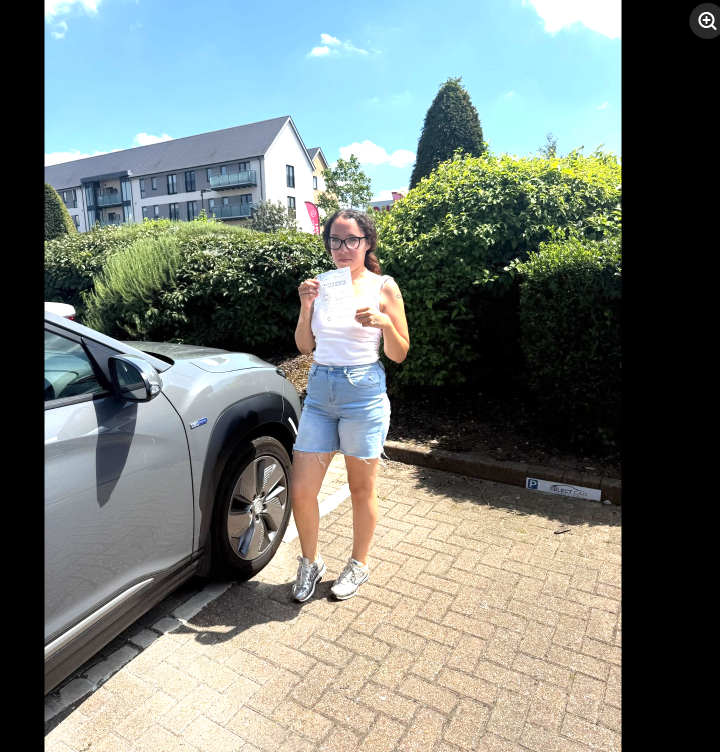 Student holding a pass certificate on a sunny test day