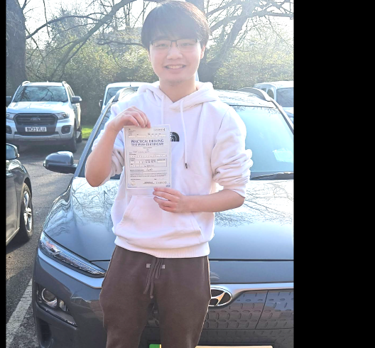 Student holding a pass certificate on a bright morning