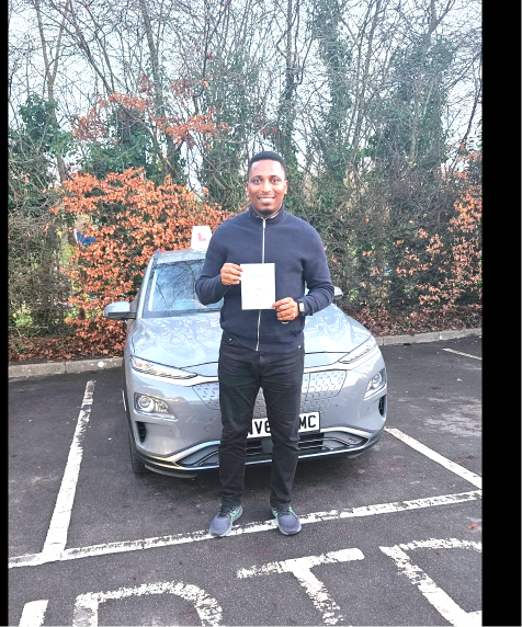 Student holding a pass certificate beside the lesson car in autumn